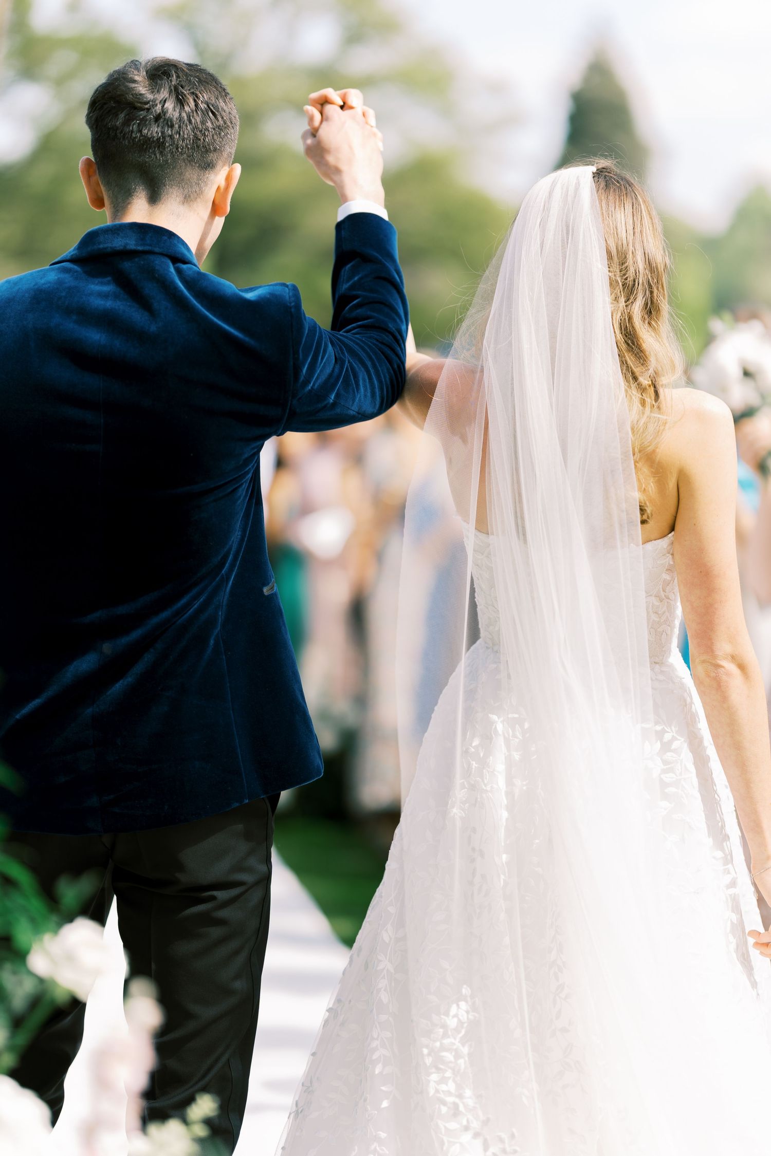 Bride and groom walking hand in hand down the aisle after outdoor wedding ceremony.
