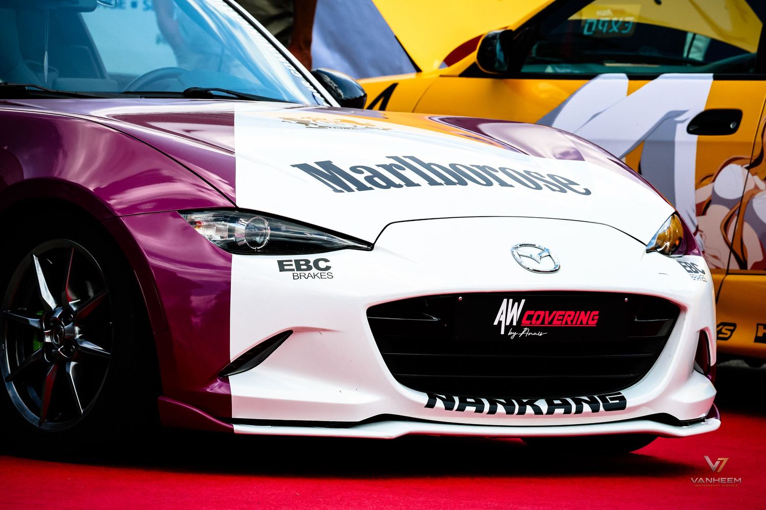 Marlboro-branded Mazda MX-5 race car with pink and white livery and Nankang tires at motorsport event.