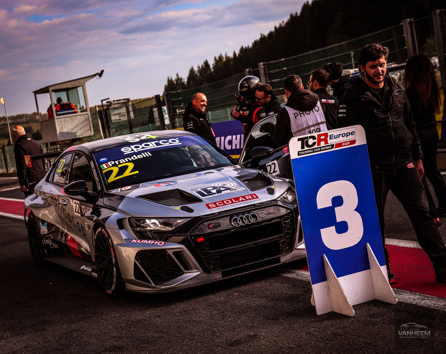 Audi TCR race car number 22 in pit lane at dusk during TCR Europe series event at Spa-Francorchamps circuit.