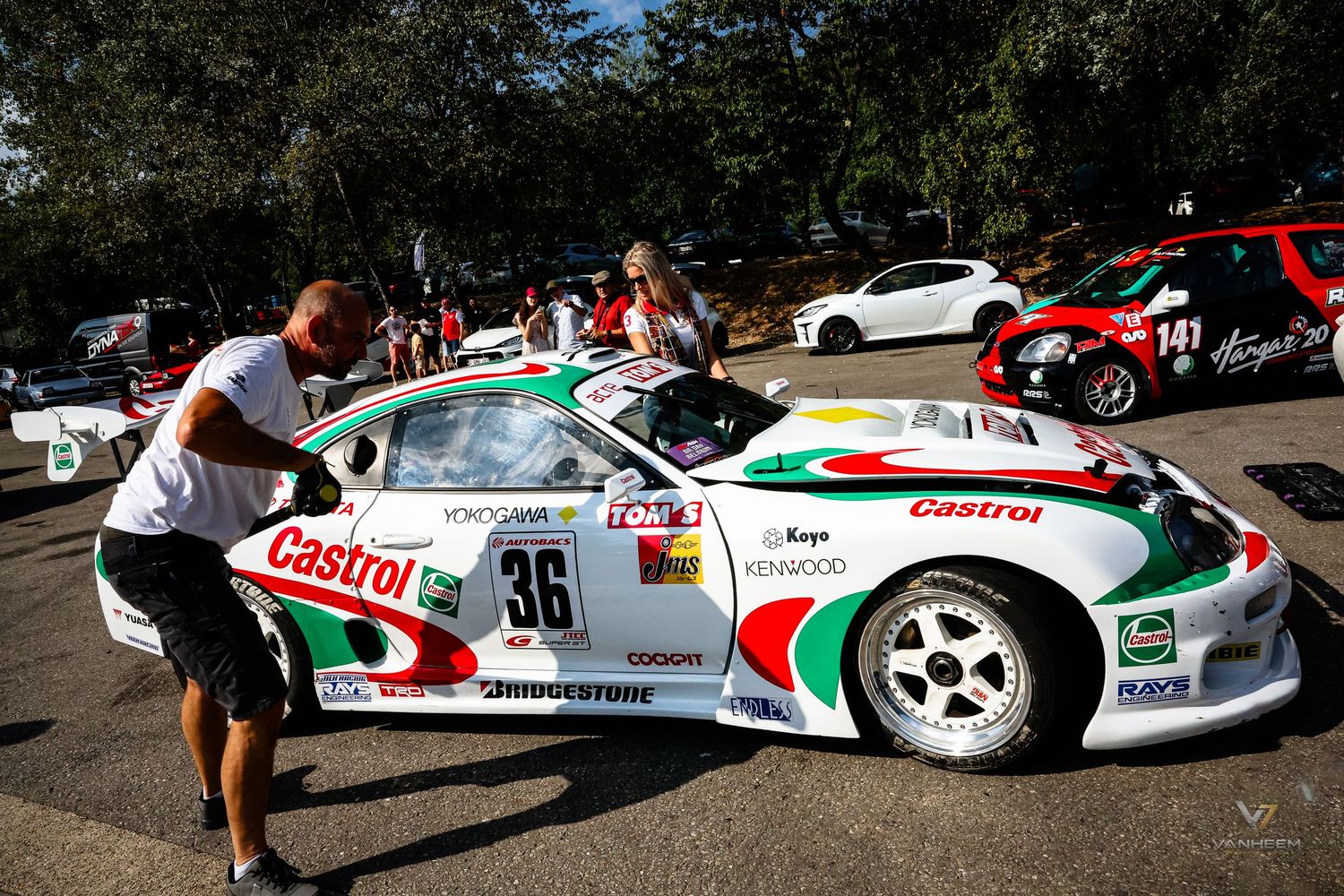 Castrol-sponsored Porsche race car number 36 with Bridgestone tires being prepared by a mechanic at an outdoor motorsport event.