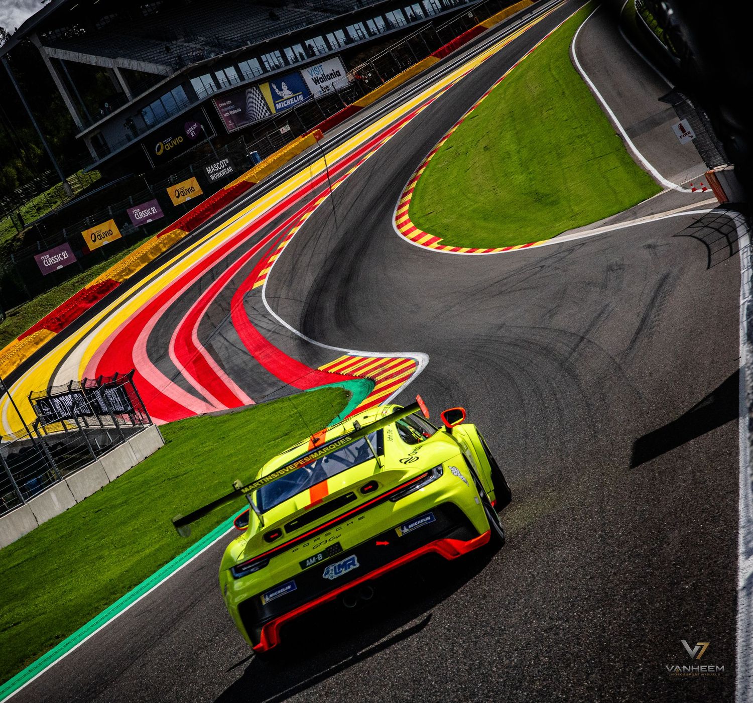 Yellow GT racing car navigating a curved track at Spa-Francorchamps circuit during a professional endurance race.