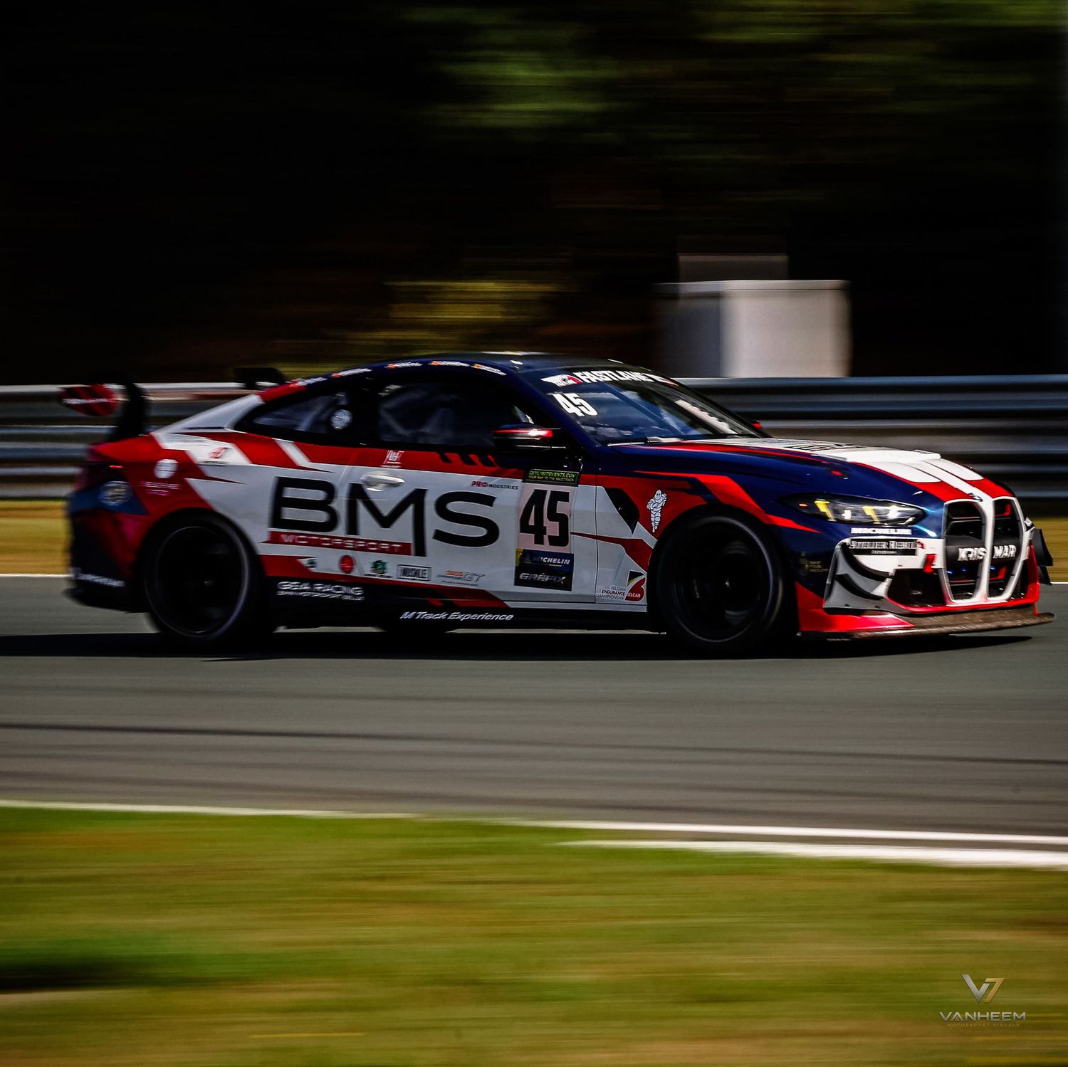 BMW BMS racing car number 45 speeding on a race track with motion blur background.