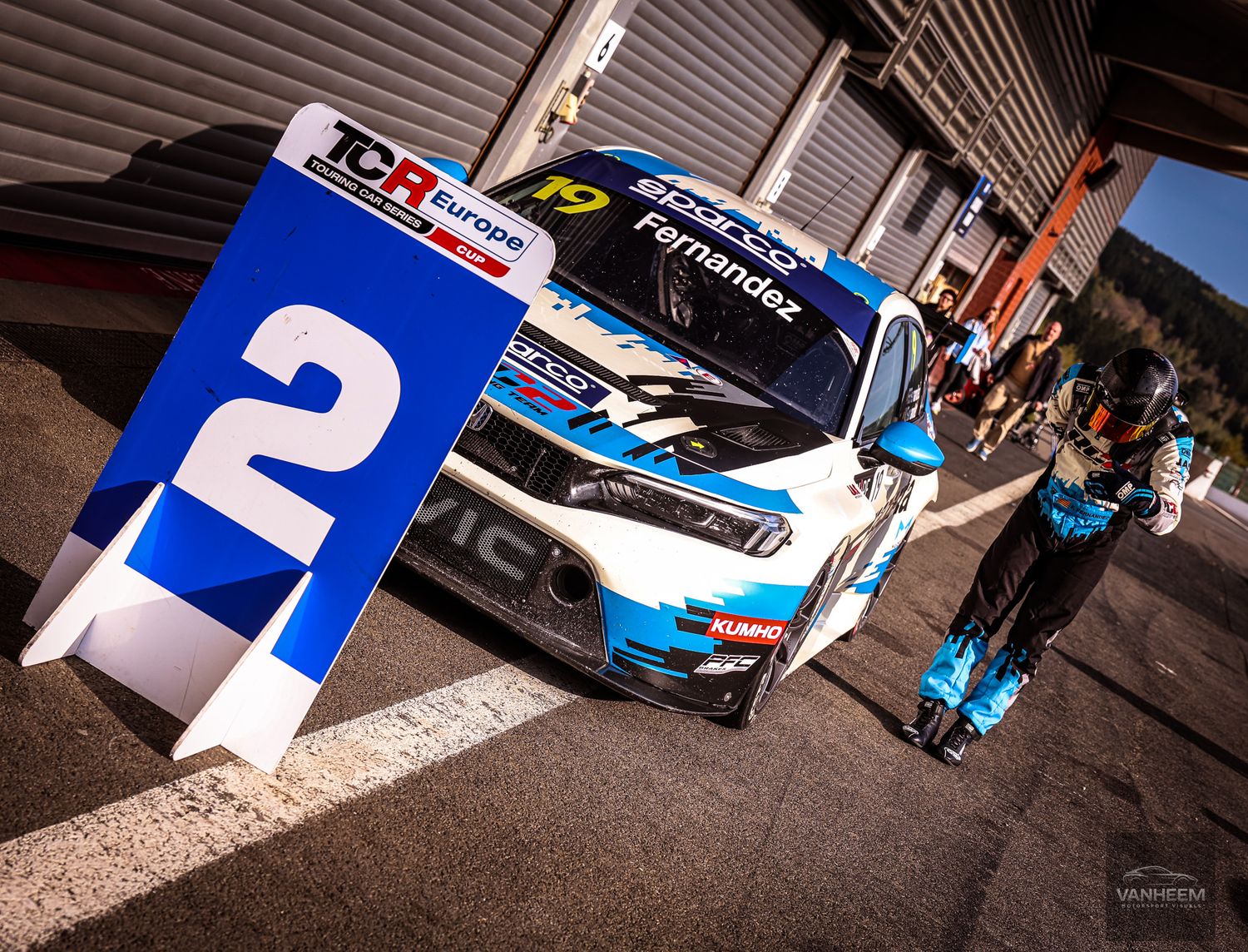 TCR Europe race car #49 Fernandez in blue and white livery parked in pit lane next to a number 2 marker.