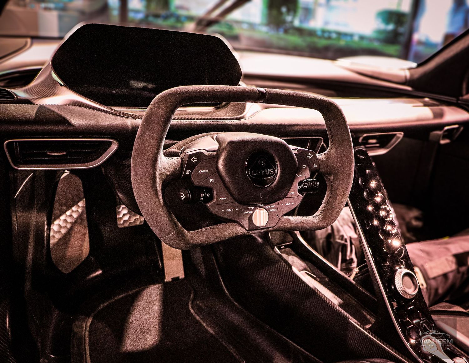 Luxury sports car interior featuring a flat-bottom steering wheel, carbon fiber trim, and racing-inspired cockpit design.