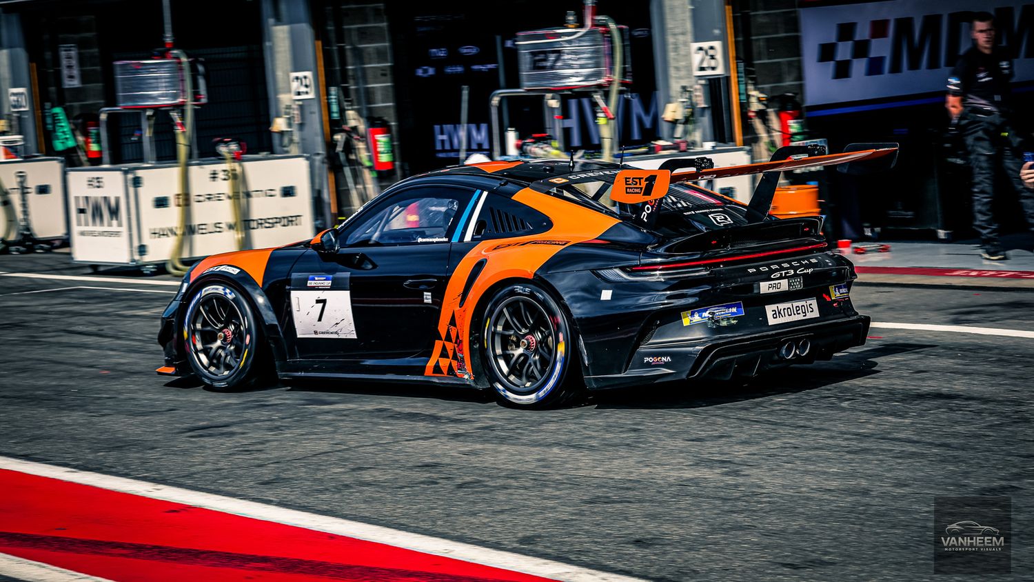 Racing cars line up on a street circuit with orange and black McLaren GT3 cars prominently featured in competition.