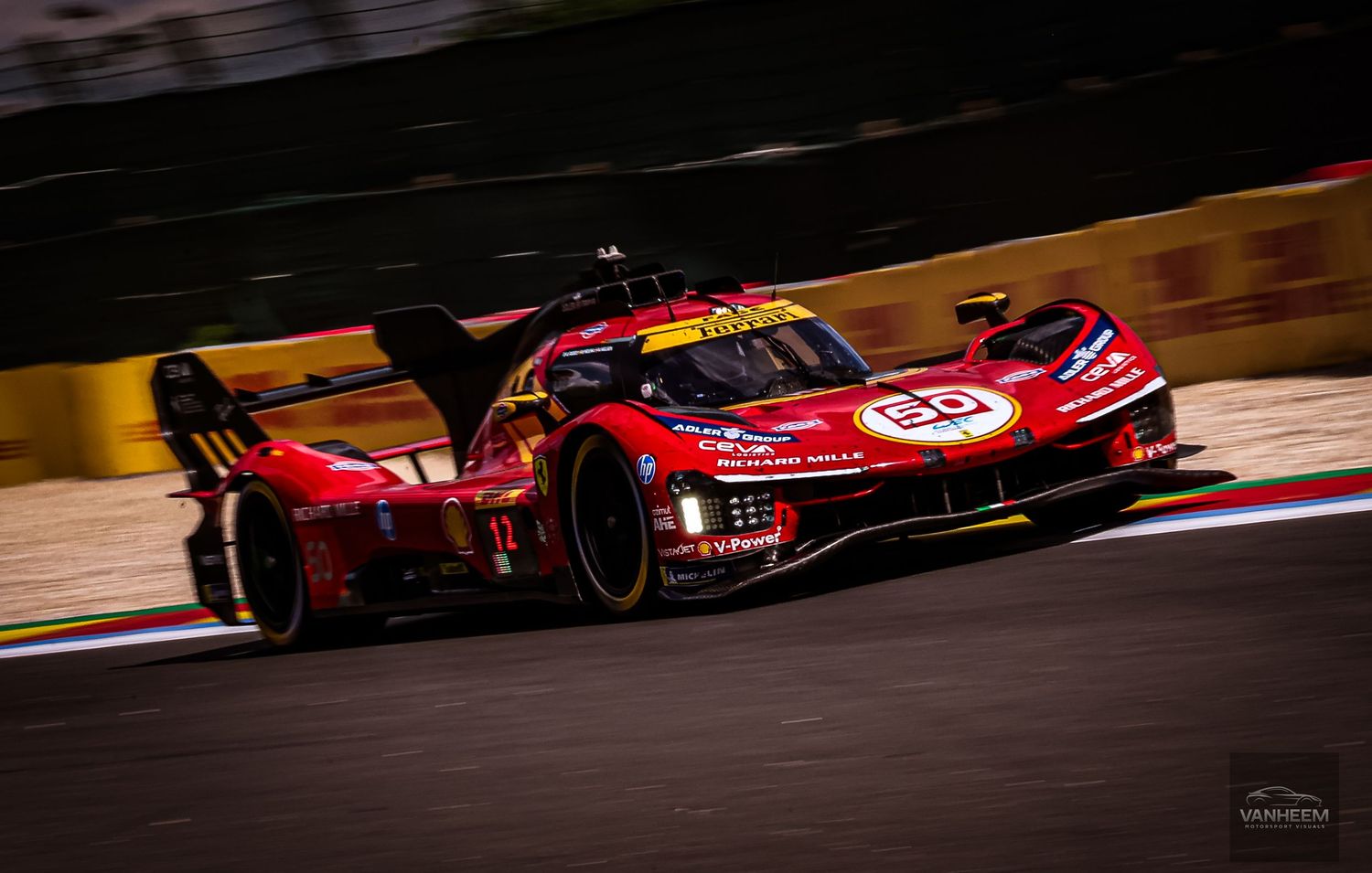 Red Ferrari hypercar racing at night on a floodlit circuit during an endurance race.
