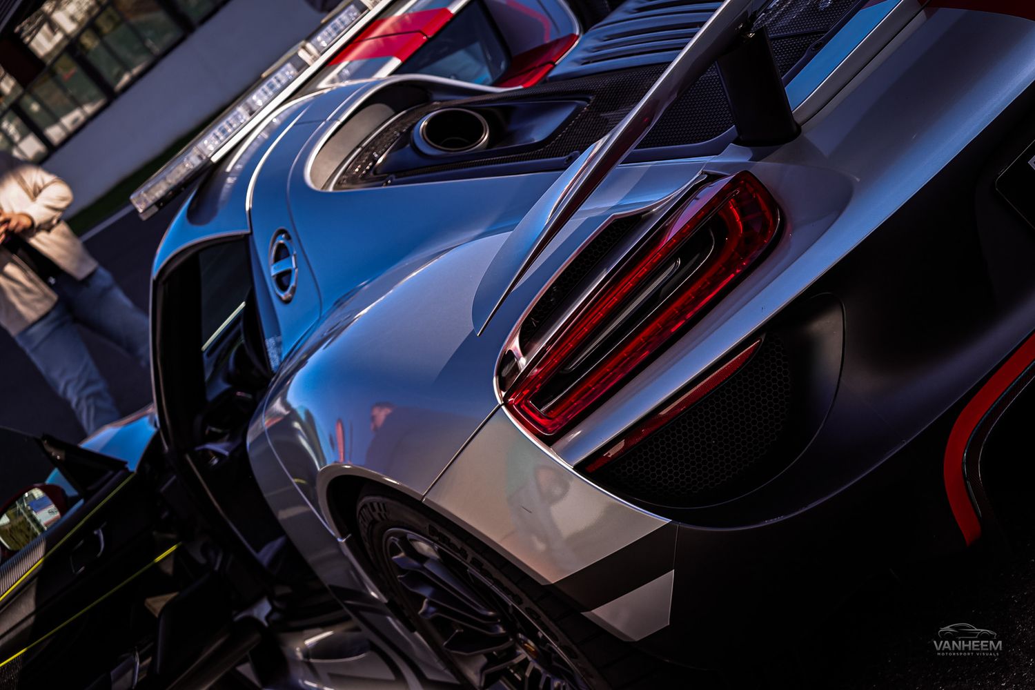 Close-up detail shots of modern sports cars showing sleek bodywork, curves, and reflective surfaces in dramatic lighting.