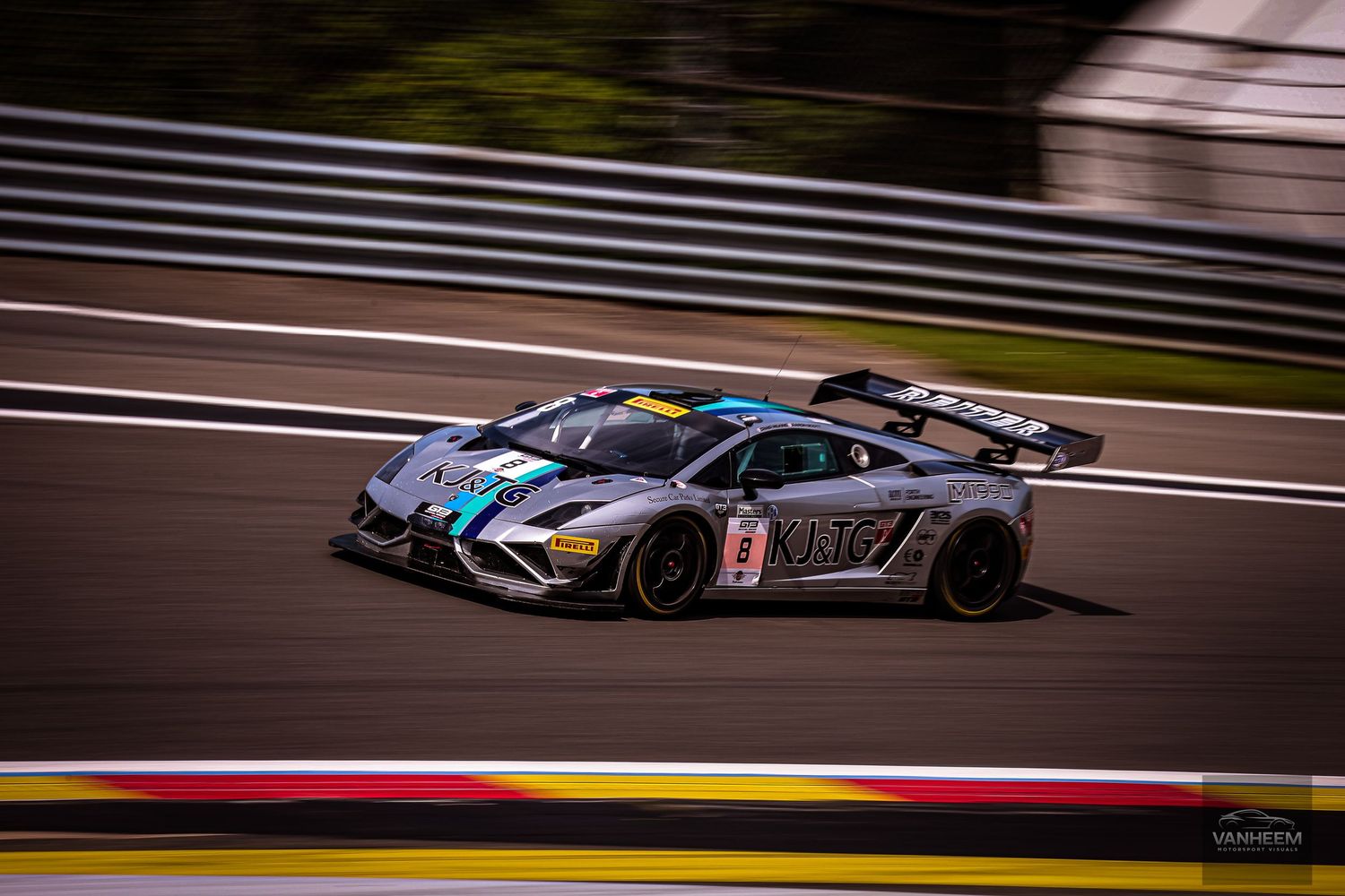 A Lamborghini GT3 race car speeds through Spa-Francorchamps circuit during a motorsport racing event.
