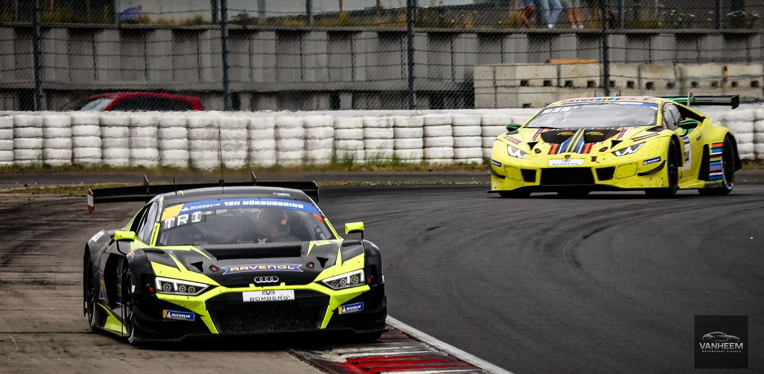 Two neon yellow Audi GT3 race cars compete on a circuit track during a professional motorsport racing event.