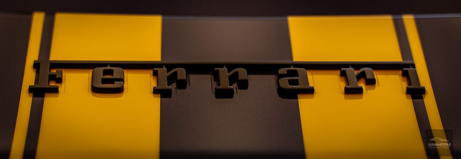 Yellow and black racing stripes on a sleek sports car create a dramatic contrast in the showroom.