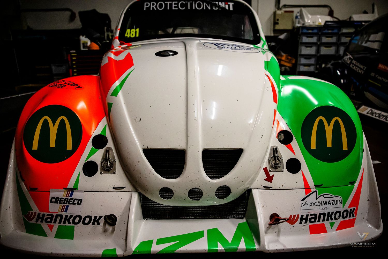McDonald's sponsored white and green racing car with Hankook tires on display in a garage pit lane.