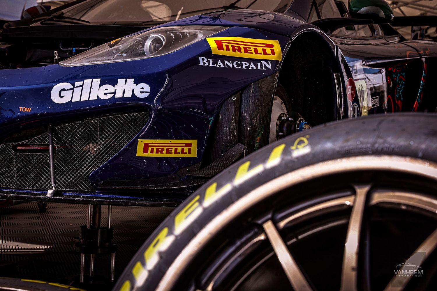Close-up of a Pirelli-sponsored Blancpain GT racing car featuring Gillette branding on its sleek dark blue bodywork.