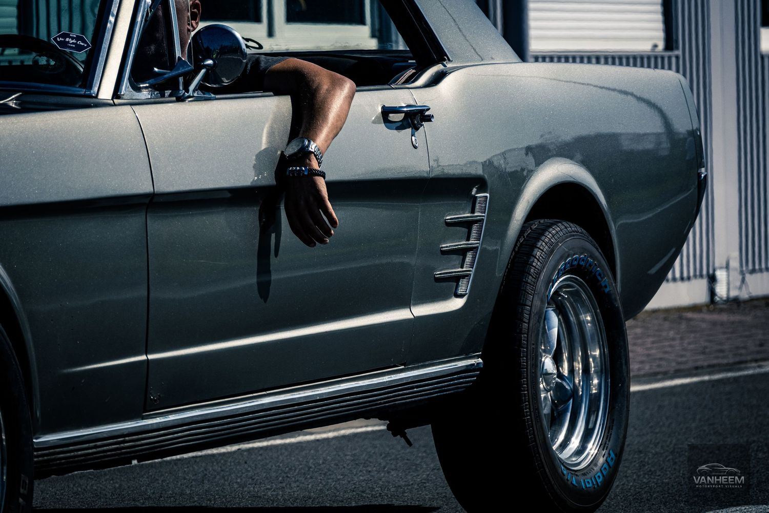 A close-up view of a black car's side panel showing sleek lines and reflective surfaces.