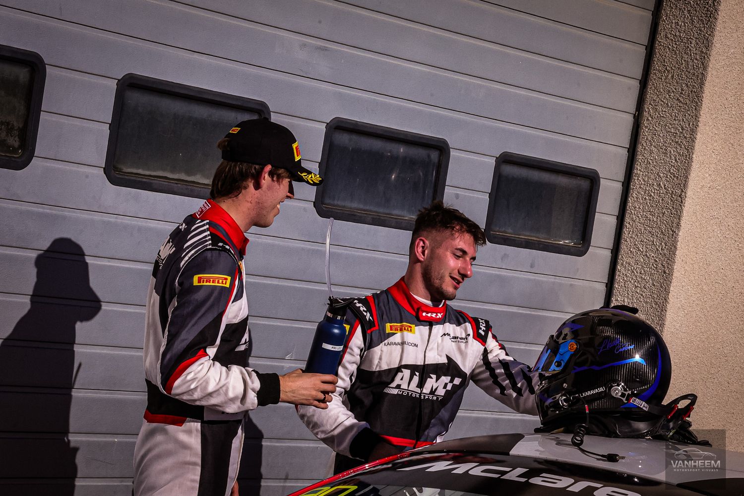 Mechanics and crew members prepare racing equipment in a garage setting.