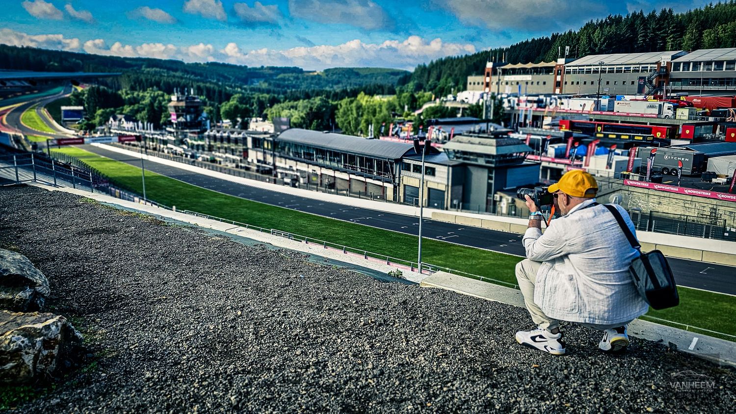 Aerial panorama of a professional racing circuit with mountains and forests in the background.
