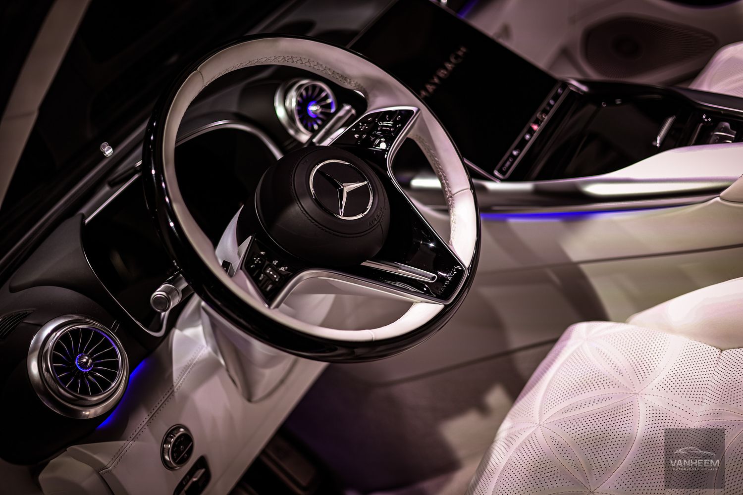 Modern luxury car interior with ambient lighting and digital dashboard displays at night.