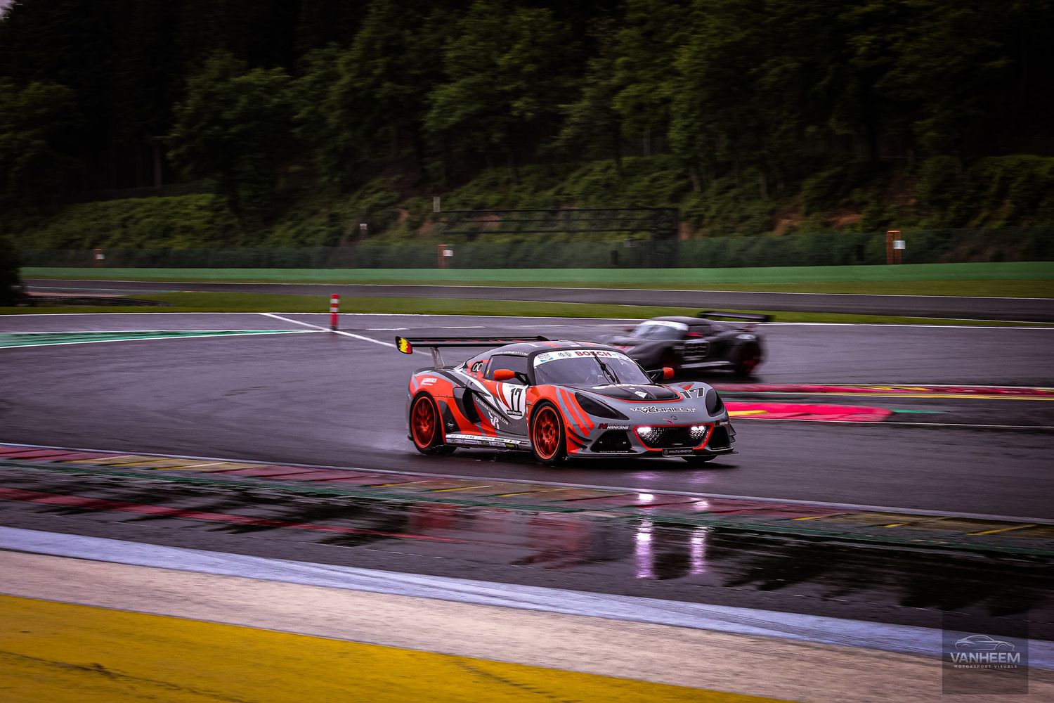 Racing cars on wet track at Spa-Francorchamps circuit during a GT endurance race in rainy conditions.