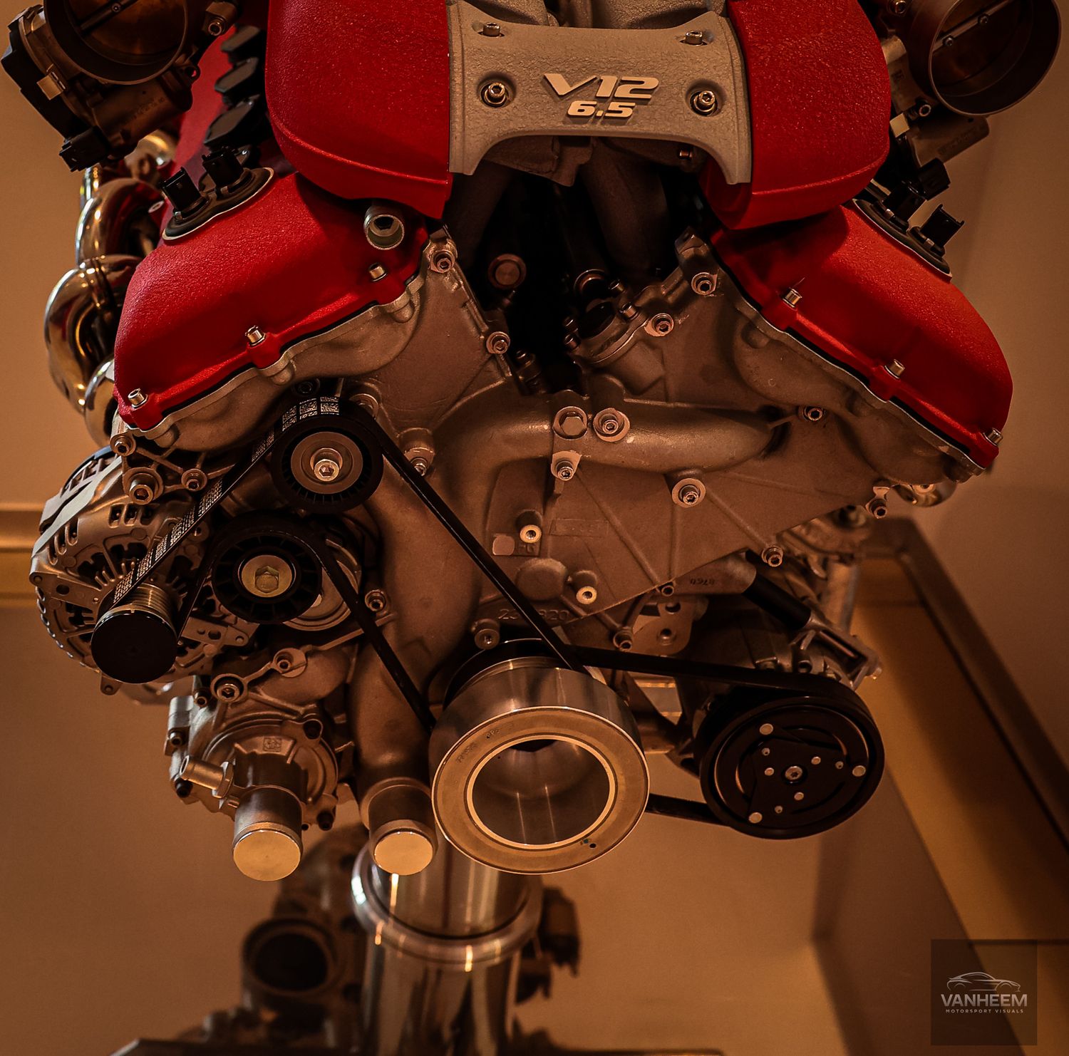 Detailed mechanical components and engine parts of a Ferrari in warm lighting.