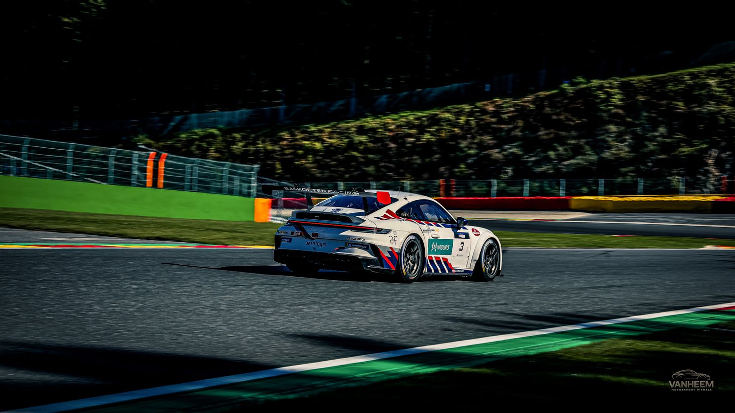 Race cars speed through a challenging corner sequence on a professional racing circuit during a competitive event.