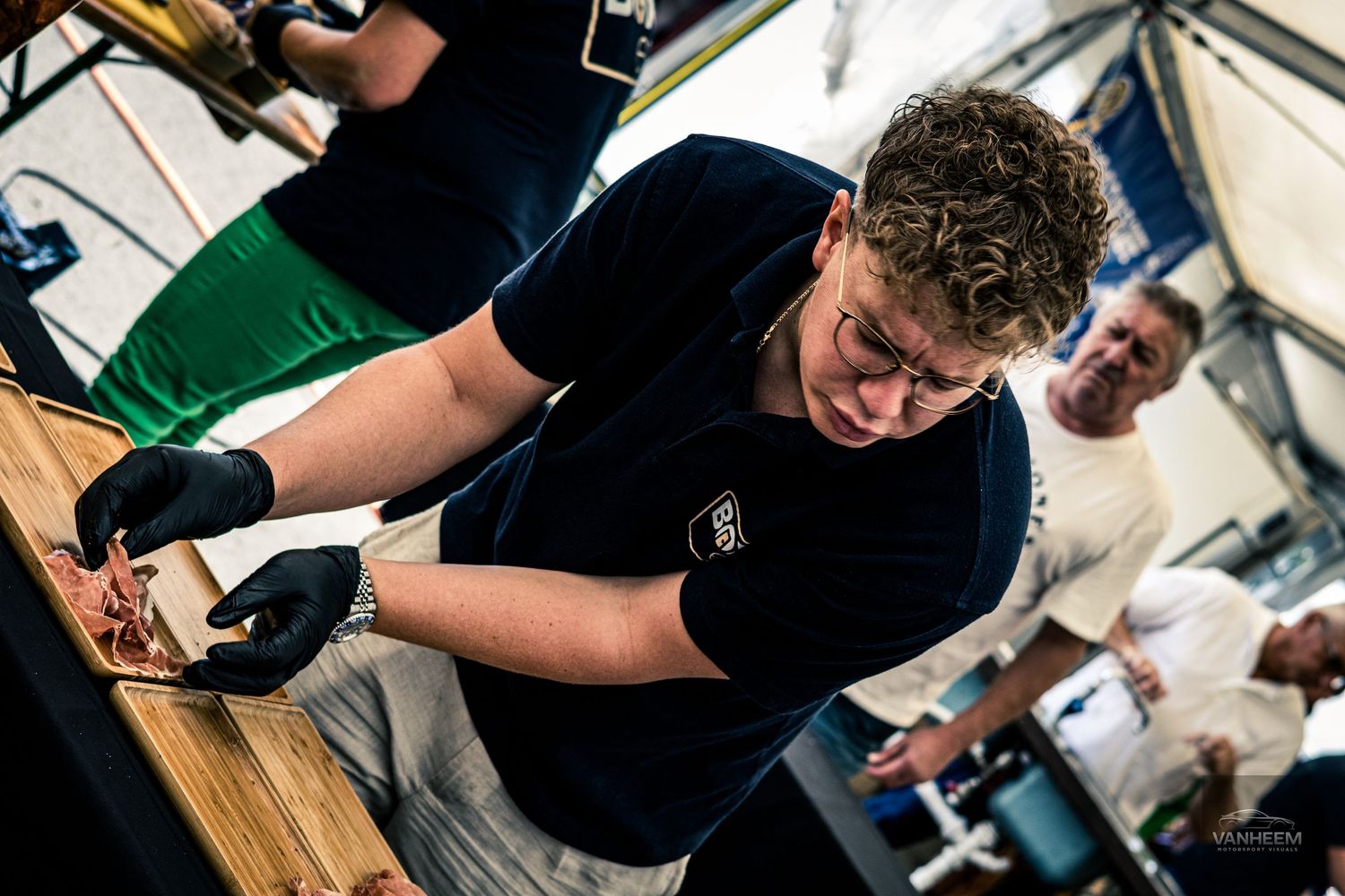 Students work on woodworking projects at workbenches in a classroom workshop setting.