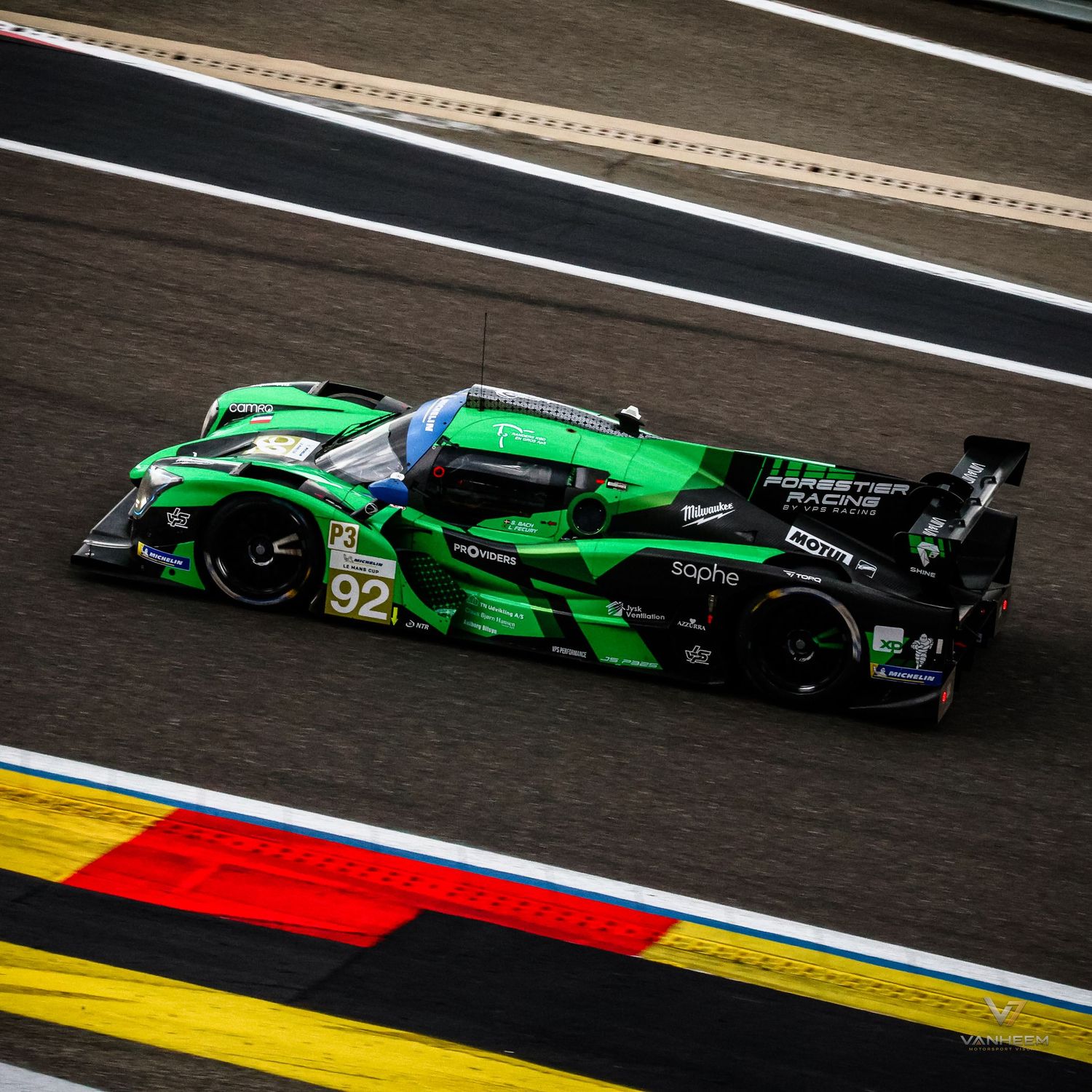 Green No. 92 LMP racing car speeding on track during a motorsport endurance race event.