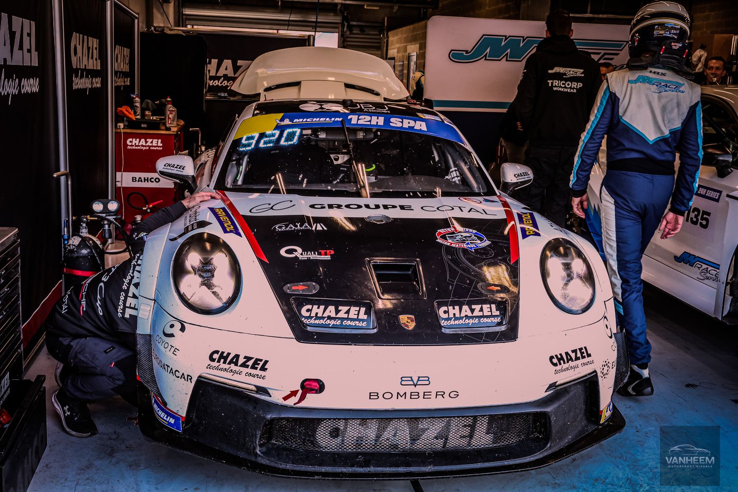 Porsche 911 GT3 race car #920 with Chazel livery parked in pit garage at 12H Spa endurance race.