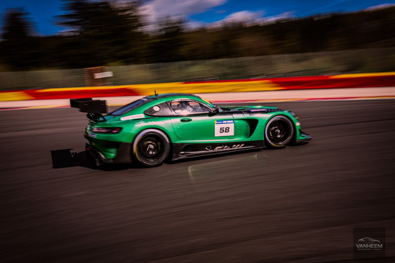 Green Mercedes-AMG GT3 racing car speeding on track at Spa-Francorchamps circuit during GT motorsport event.