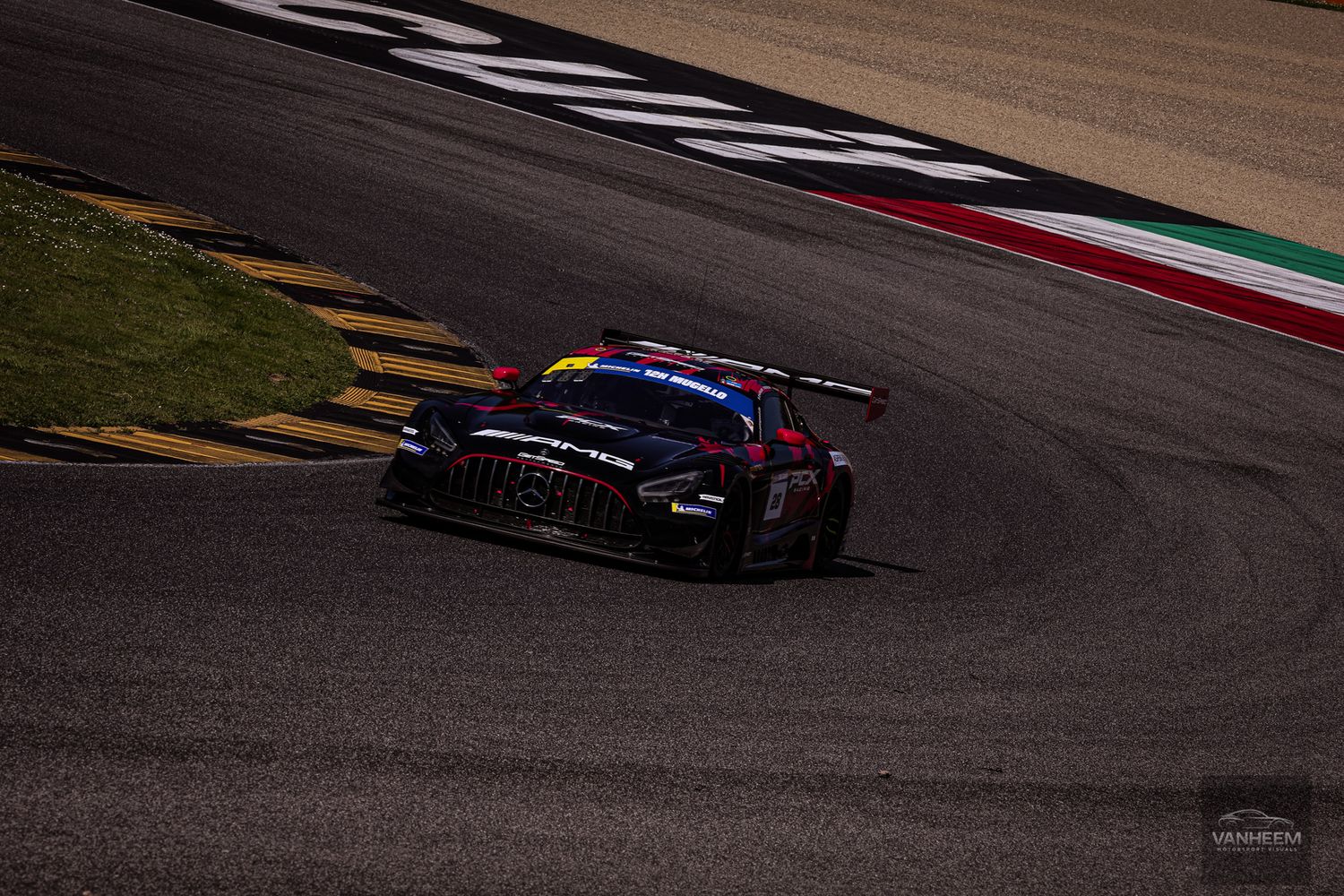 Racing cars navigate a challenging curve on a professional racetrack during a motorsport competition.