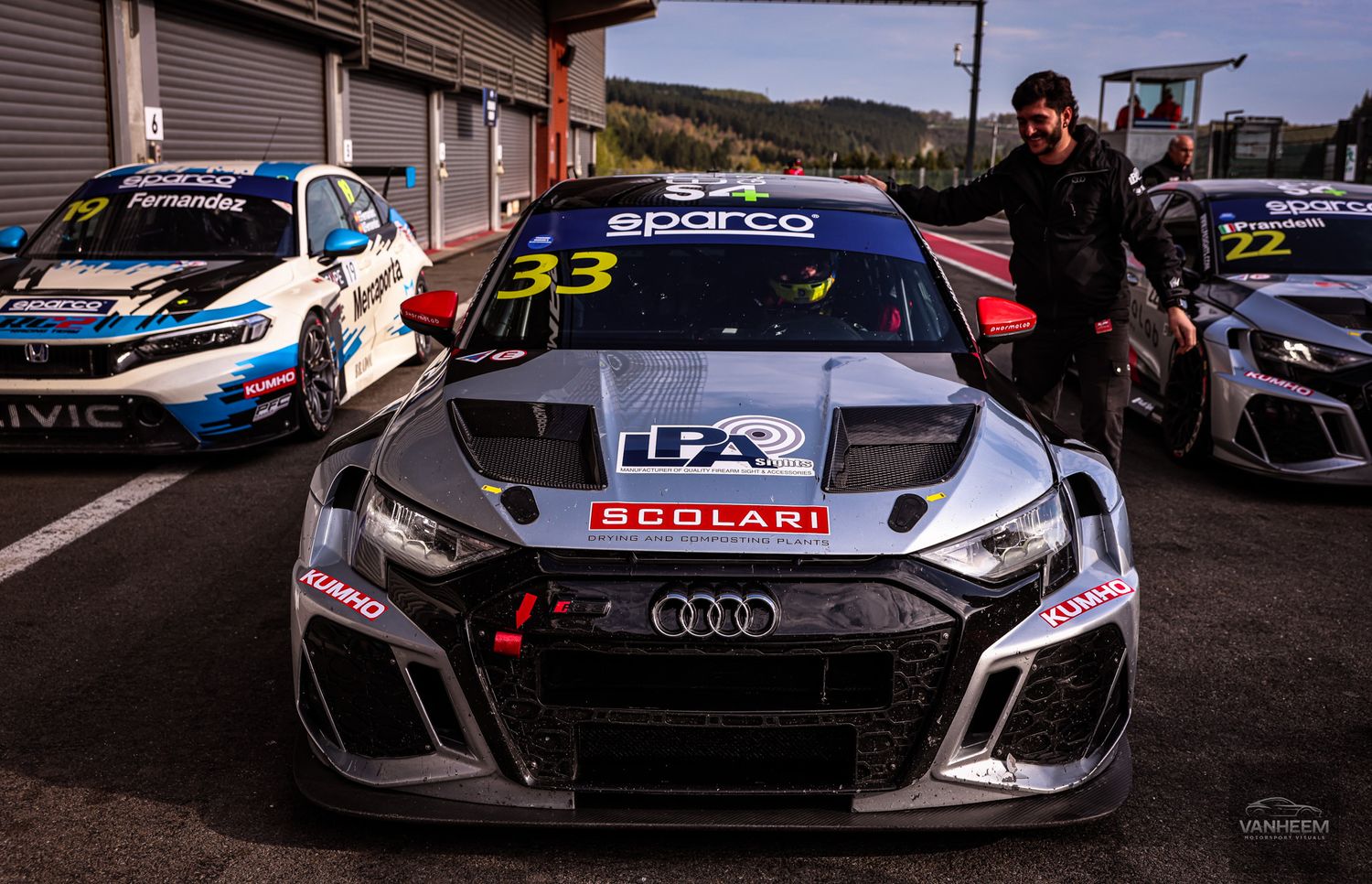 Audi TCR racing car number 33 with Scolari livery parked in pit lane at a motorsport circuit.