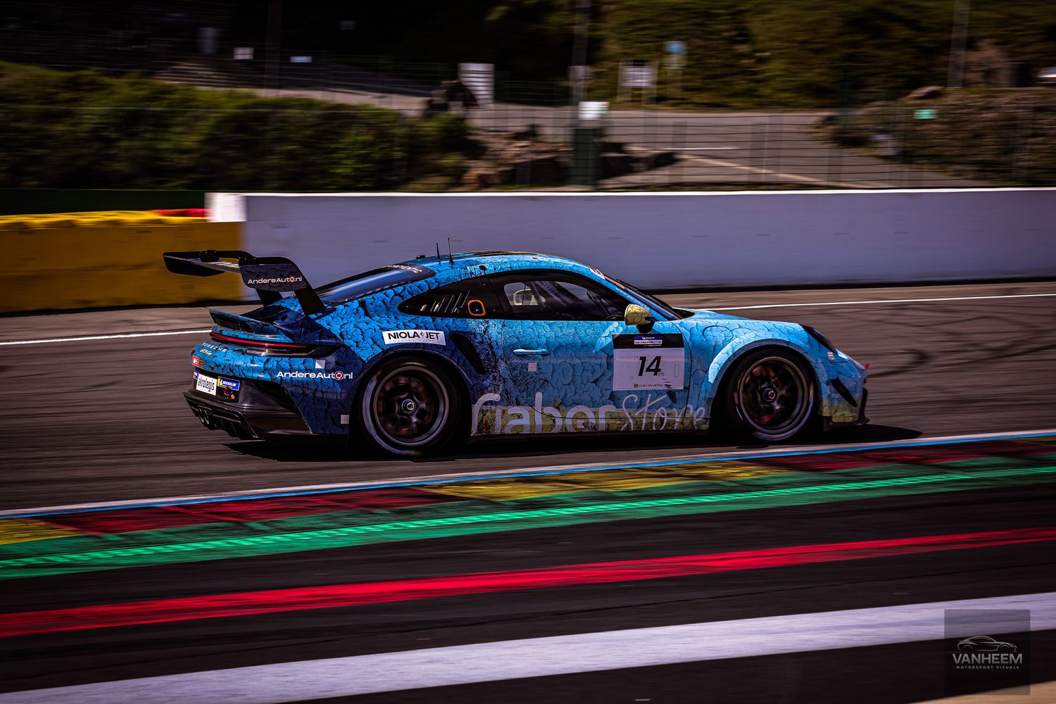 Race cars speeding along illuminated track with blue and red curbing.