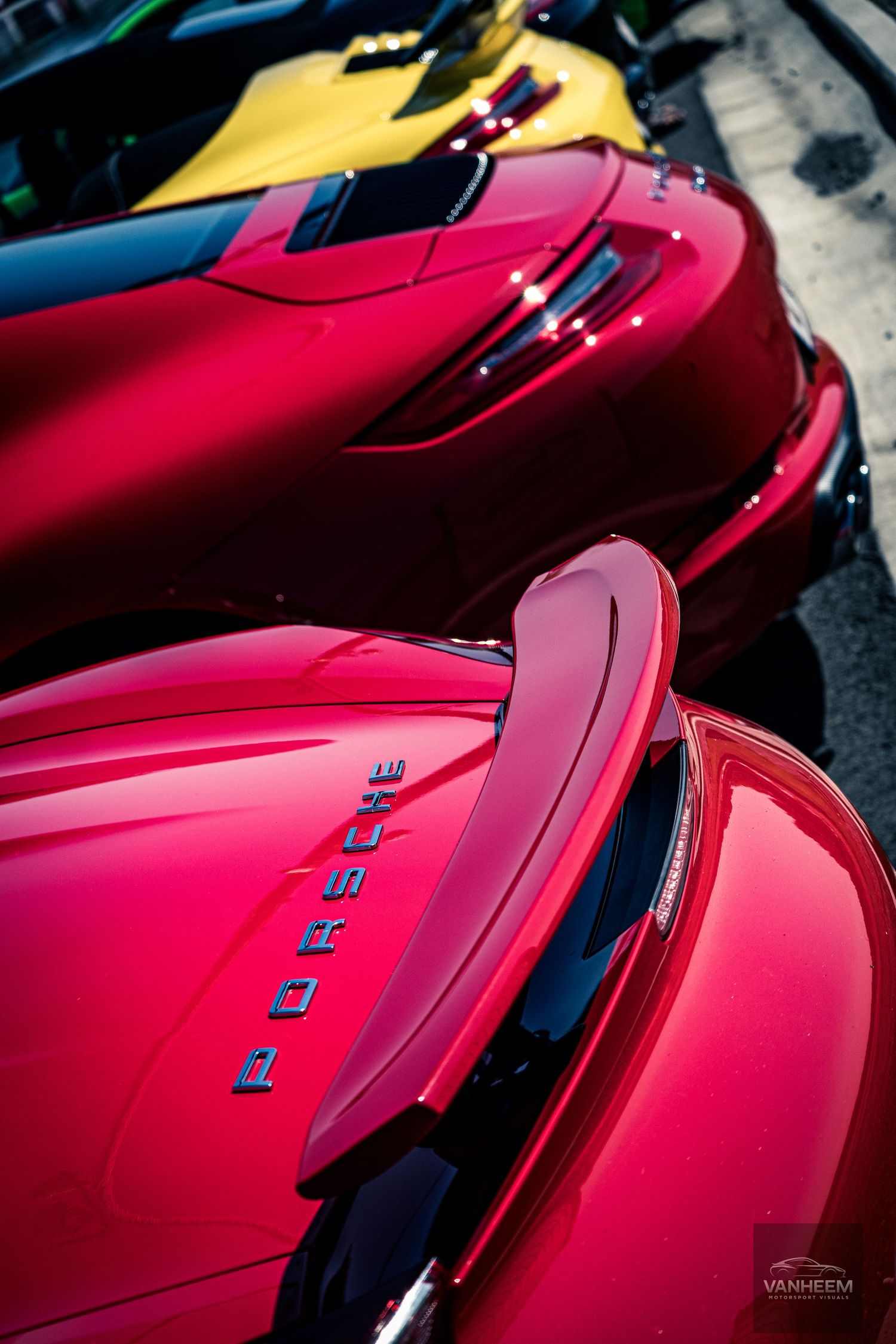 Close-up view of red Ferrari sports cars lined up showing their sleek curves and distinctive design elements.