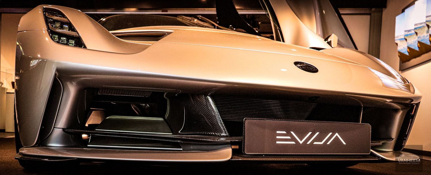 Lotus Evija electric hypercar front fascia showcasing sleek aerodynamic design and futuristic styling at an auto exhibition.