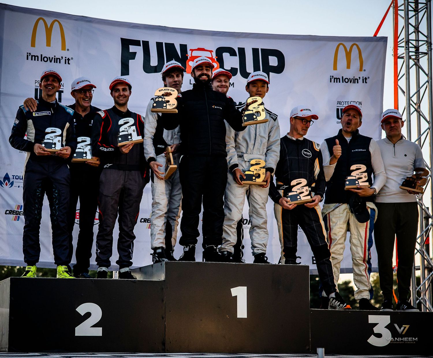 Racing podium ceremony at Fun Cup with McDonald's sponsorship, winners holding trophies on numbered platforms 1, 2, and 3.