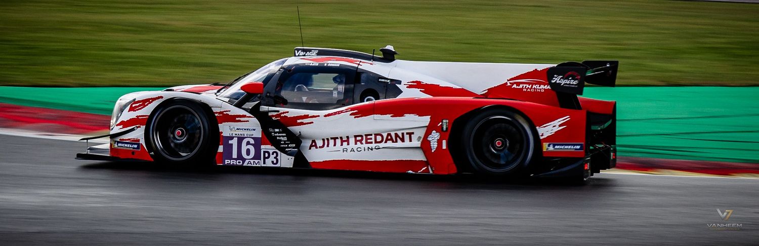 Red and white LMP racing car number 18 with Earth Redant livery speeding on track during endurance race.