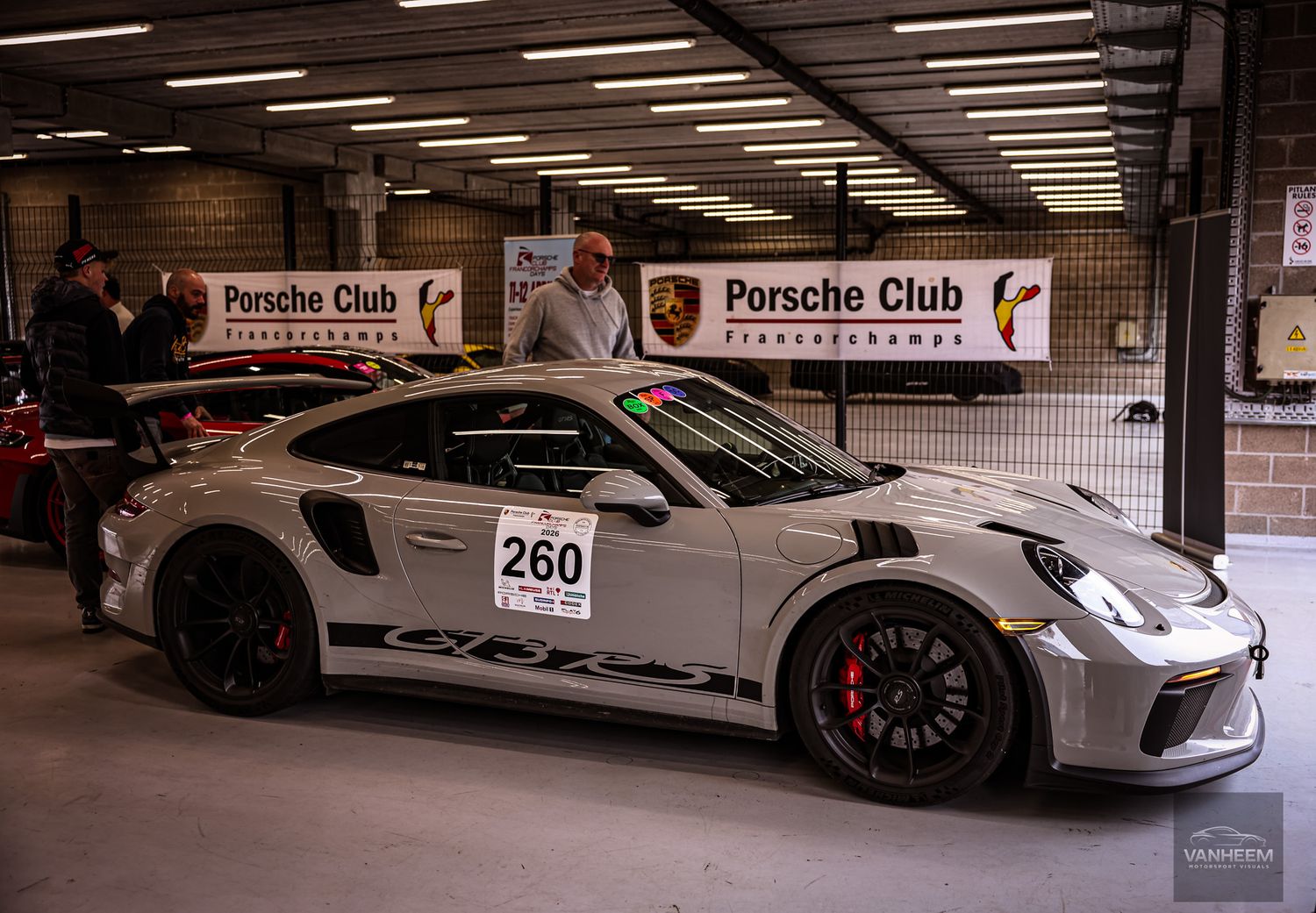 White Porsche 911 GT3 RS race car number 260 in Porsche Club Francorchamps pit garage.
