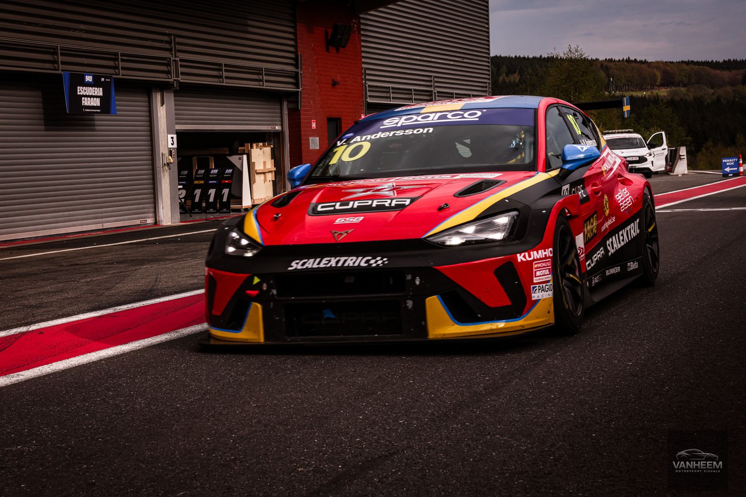 Red and black CUPRA racing car on track, featuring Scalextric sponsorship livery during a motorsport competition.