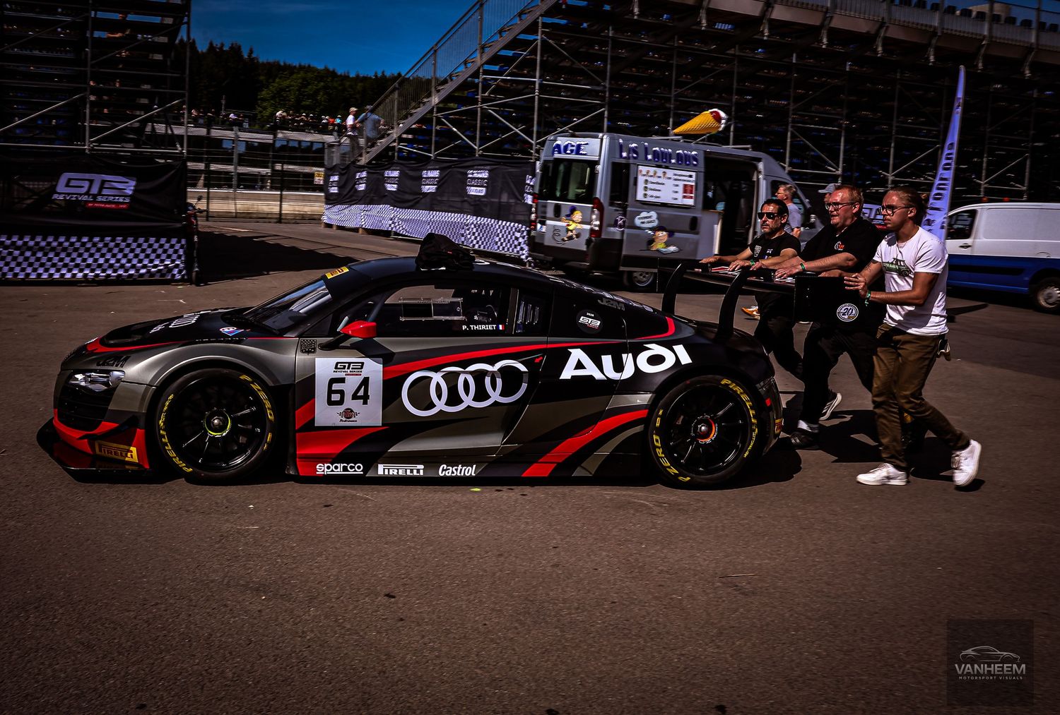 Audi GT3 race car number 54 being pushed by crew members in pit lane at a motorsport racing event.
