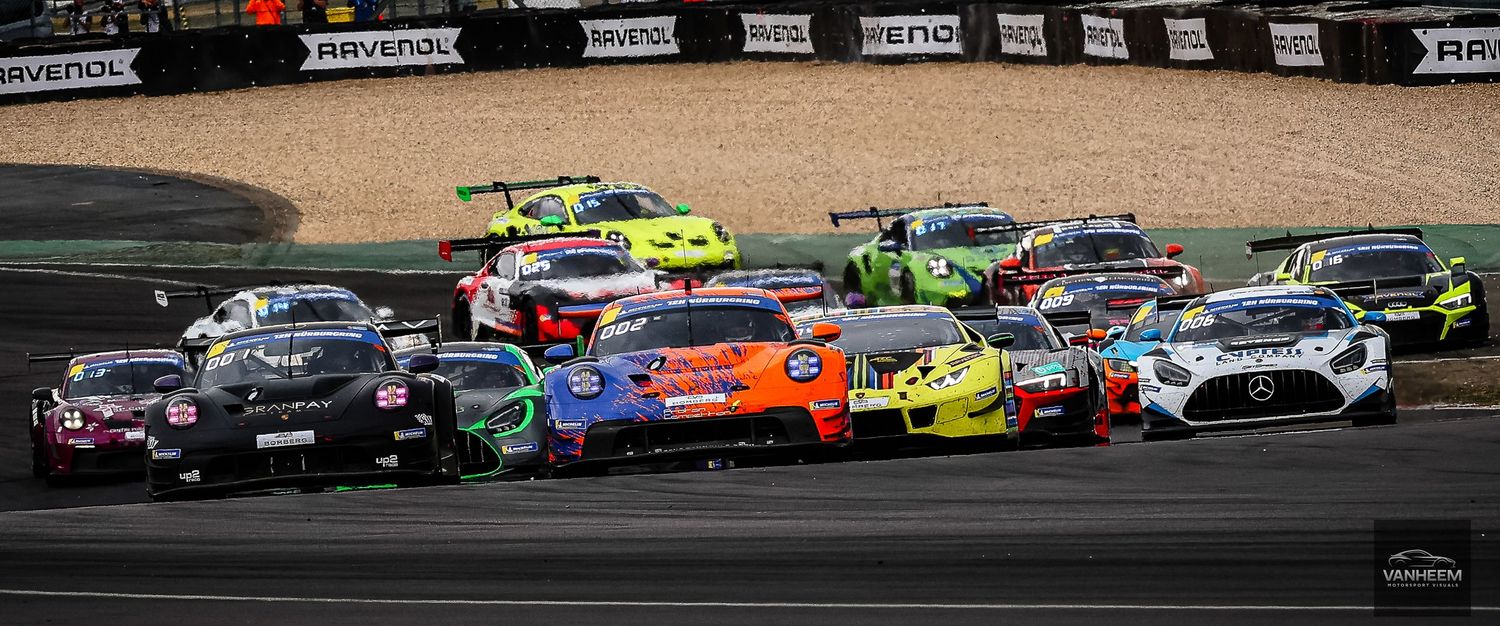 Multiple GT racing cars including Porsche and Mercedes compete in a packed race start on a circuit track.