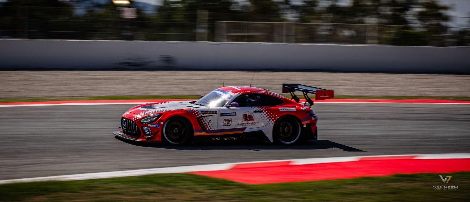 A white and red Mercedes-AMG GT3 race car speeding on a racing circuit with red curbing visible.