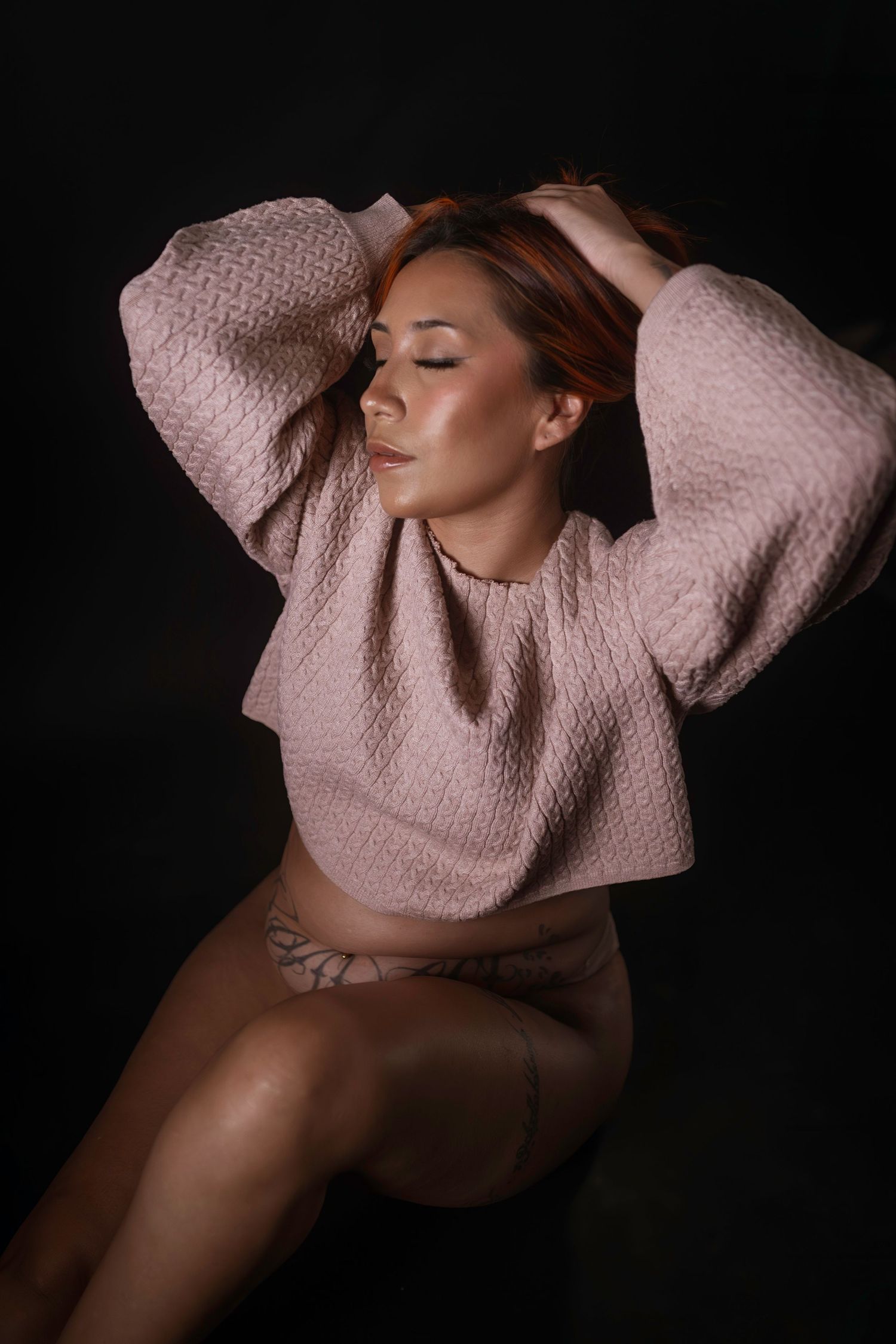 Woman with arms raised in soft light, artistic boudoir session Fort Worth, TX.