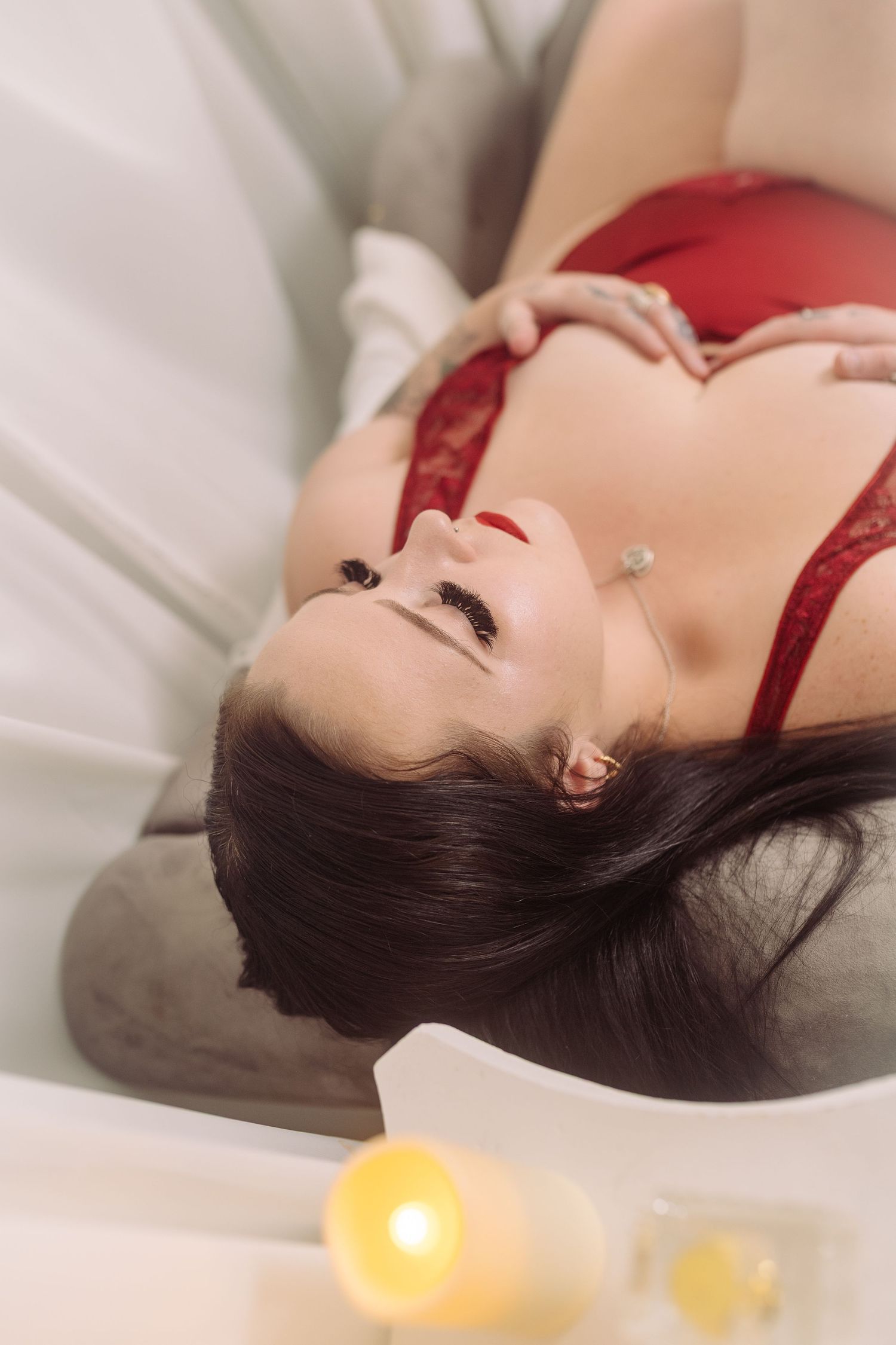 Boudoir photography Fort Worth, client reclining in red lingerie during luxury studio session.