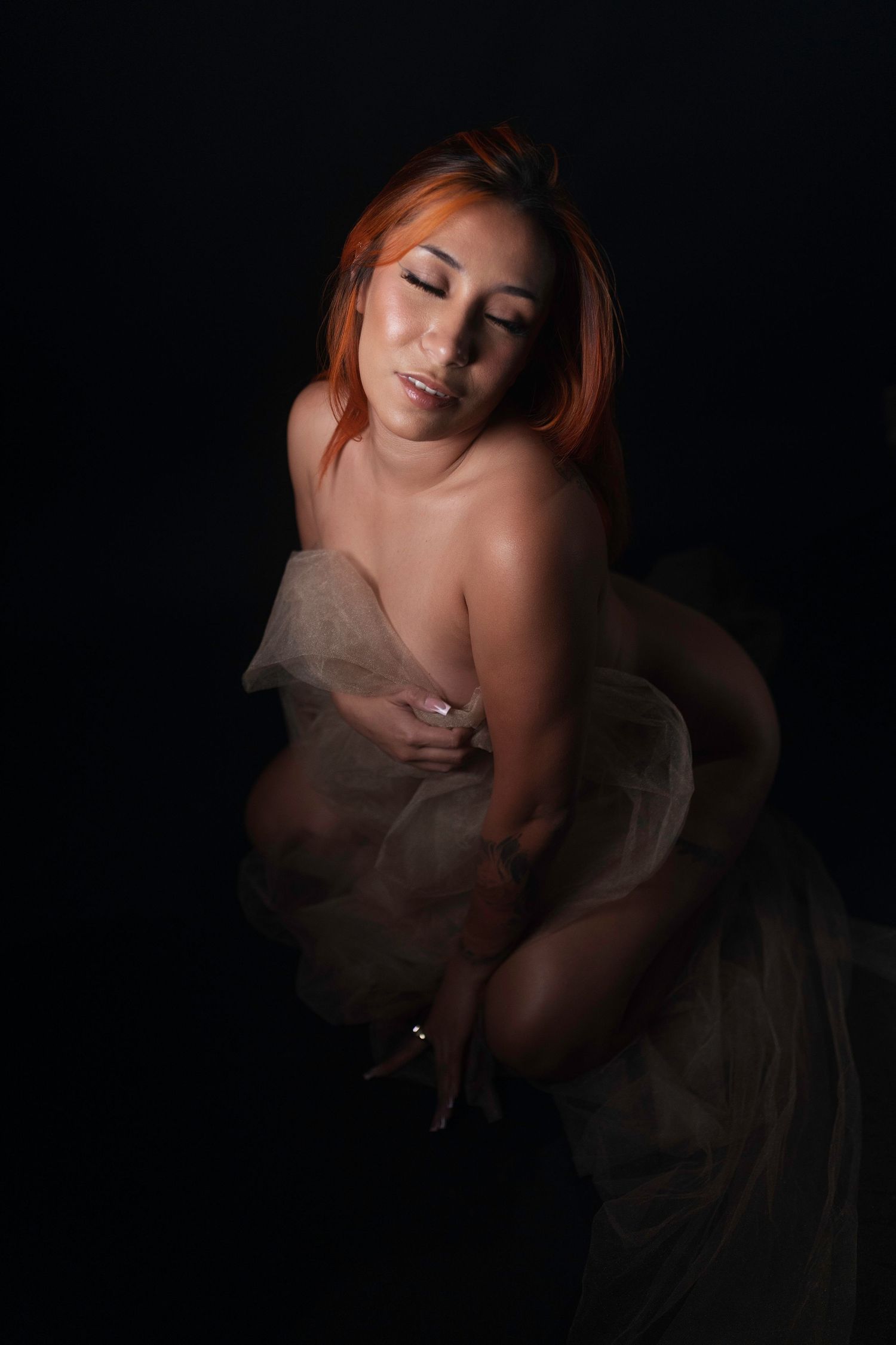 Dramatic low-light boudoir portrait, woman gazing forward, Fort Worth boudoir photography.
