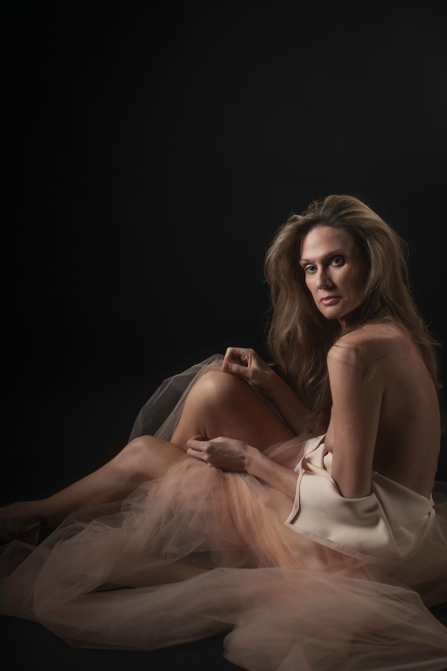 Woman in dress in intimate seated pose, DFW boudoir photography session at Lock & Key Fort Worth.