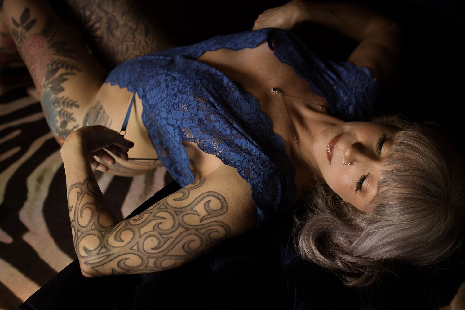 Boudoir photo of a tattooed woman in blue lace lingerie, eyes closed, Lock & Key Photography Dallas-Fort Worth Texas.