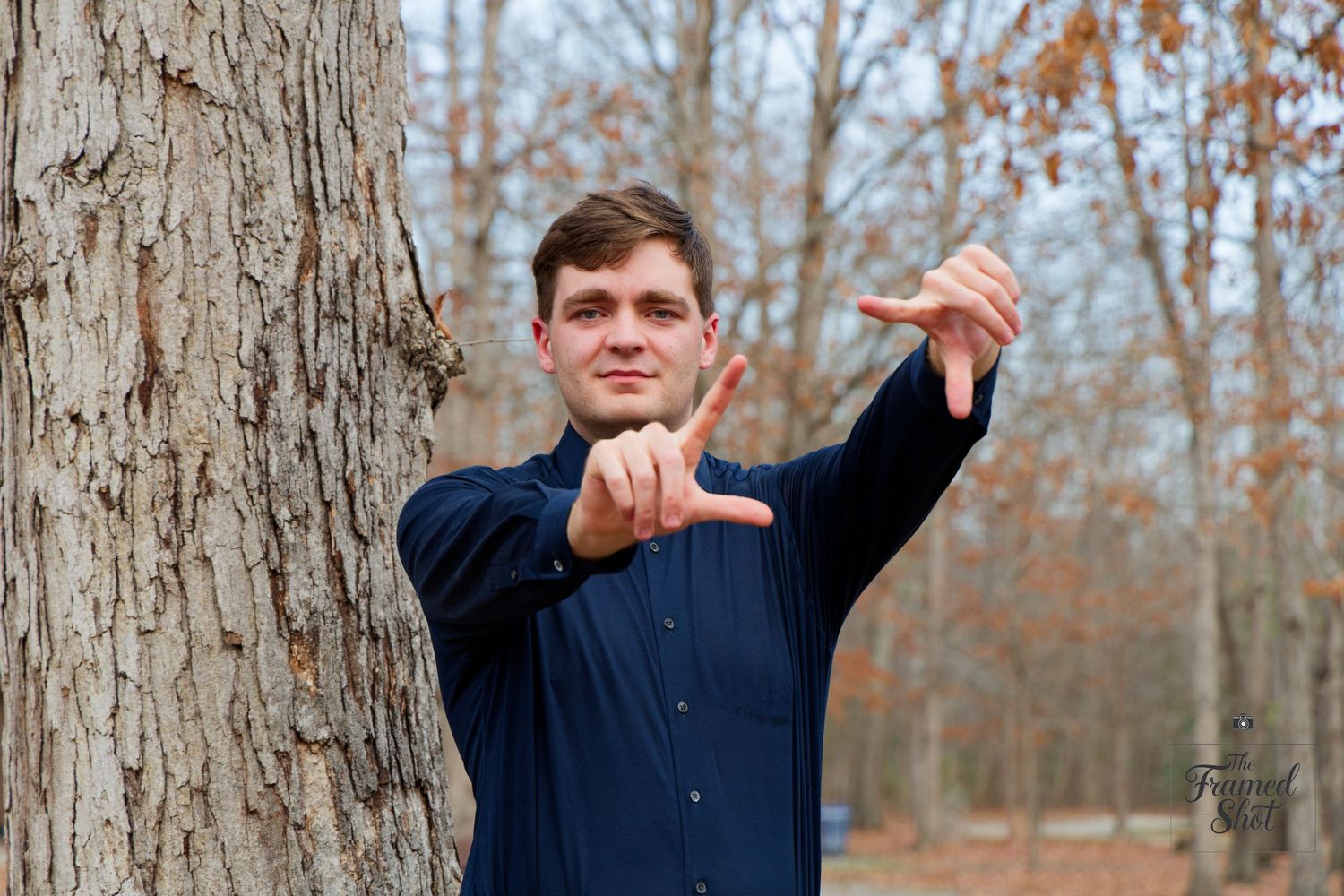 A person in a navy shirt makes a heart shape gesture while standing next to a tree. Ironbridge Park, Chesterfield, Outdoors, RVA, Richmond