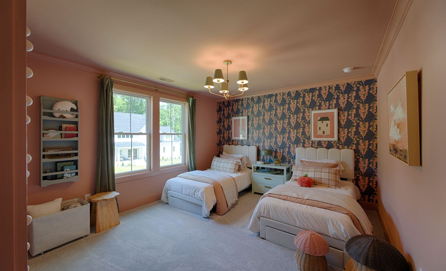 Cozy kids bedroom with floral wallpaper, twin beds, pink walls, chandelier, and large window with natural light.