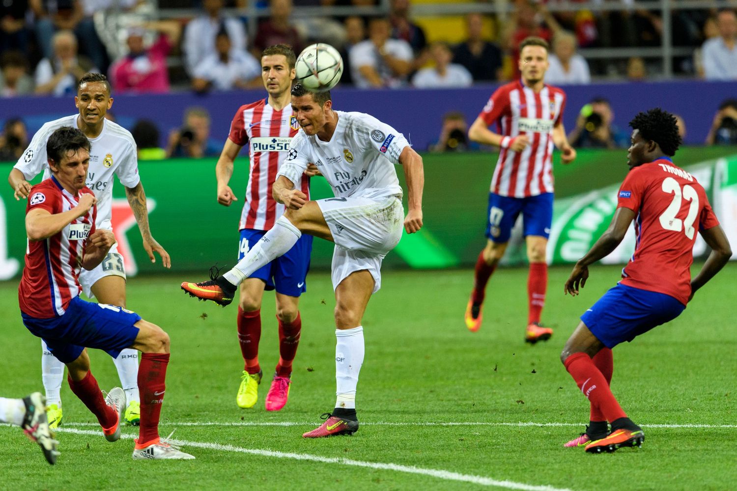 Soccer players compete for the ball during an intense Champions League match between Real Madrid and Atletico Madrid.