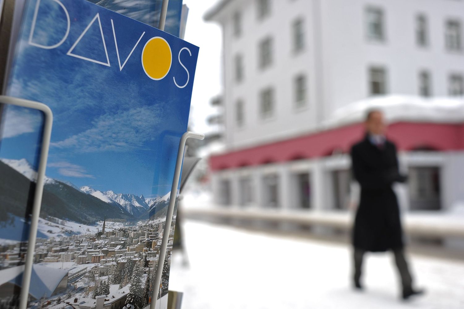 A Davos travel postcard displayed and a blurred figure in winter walking during the World Economic Forum (WEF).