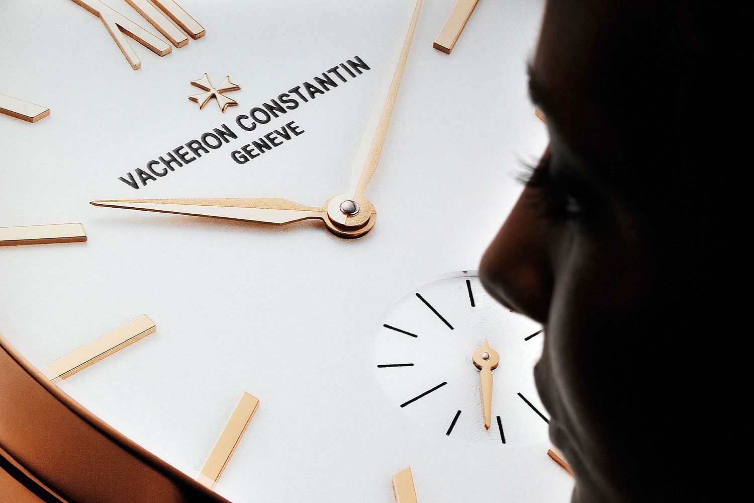 Close-up of elegant Vacheron Constantin Geneve watch face with rose gold details.