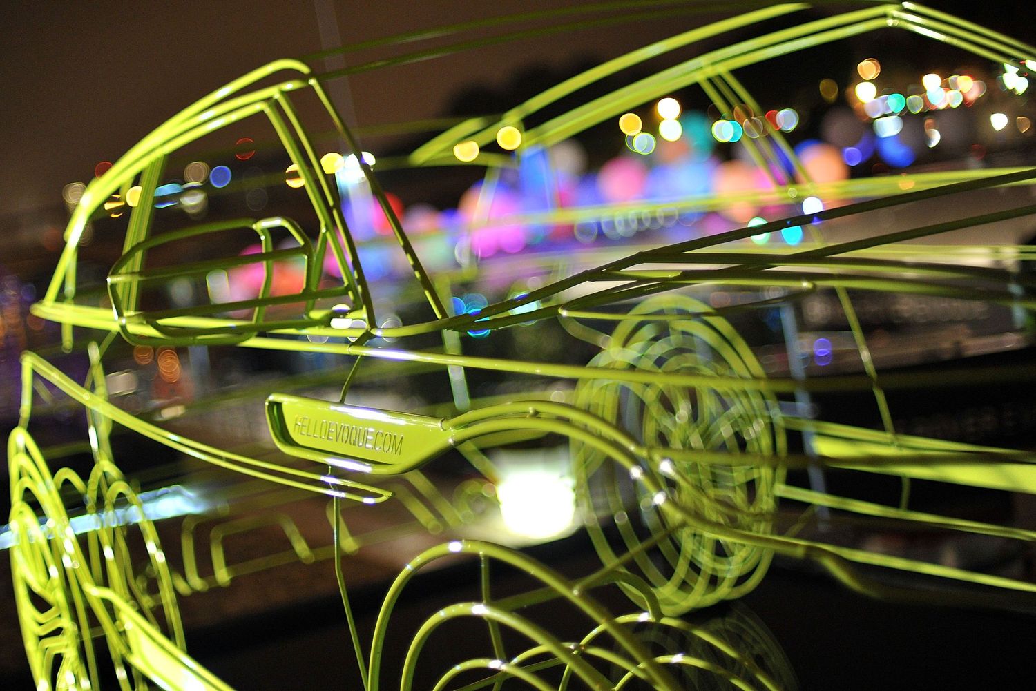 Range Rover Evoque eon yellow light painting art of a car outline against colorful bokeh city lights at night.